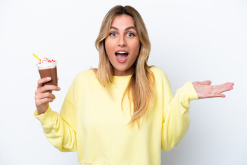 Young Uruguayan woman holding Frappuccino isolated on white background with shocked facial expression