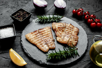 grilled pangasius white fish fillet with spices on a stone background 