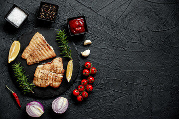 grilled pangasius white fish fillet with spices on a stone background with copy space for your text