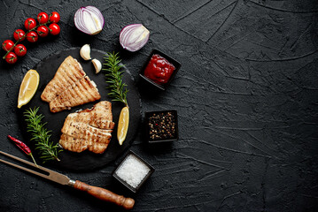 grilled pangasius white fish fillet with spices on a stone background with copy space for your text