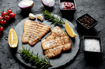 grilled pangasius white fish fillet with spices on a stone background 