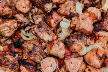 Pieces of appetizing fried meat with onions lie on a dish. Grilled meat.