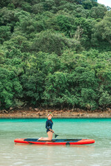 A single woman rowing in the middle of the sea enjoying the blue ocean view at the beach. Pictures of travel and relaxation at the sea of ​​Thailand.