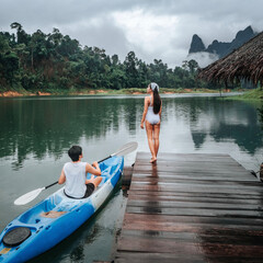 Couple riding a boat on a floating raft for a relaxing holiday or vacation in Thailand, Khao Sok, Cheow Lan Dam. Ratchaprapha Dam