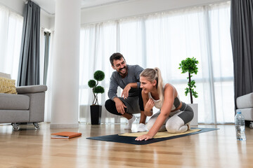 Woman with her personal fitness trainer. Couple exercising together. Man and woman in sports wear doing workout at home. Healthy lifestyle training with coach instructor for better life