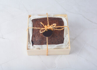 premium freshly baked dark cocoa chocolate brownie square cake with walnut in wood bento box on...