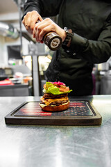 chef hand cooking cheeseburger on restaurant kitchen