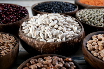 close up dried legumes white beans in wooden bowl