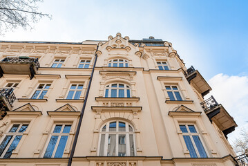 Facade of old tenement house, residential building with balconies. Low angle view of renovated...