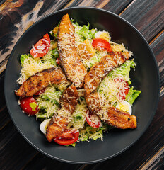 Delicious fresh salad with red fish on wooden table