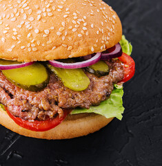 Tasty cheeseburger isolated on black stone