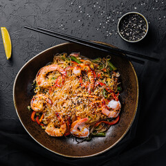 Stir fry noodles with vegetables and shrimps in black bowl