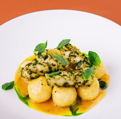 Baked fish fillet and potatoes on white plate