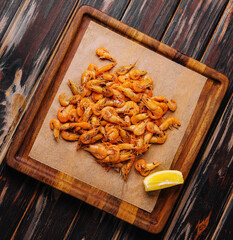 Small cooked shrimp on wooden tray