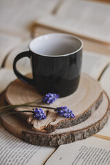 book and a cup of coffee with spring flower blooming, grape hyacinth, muscari