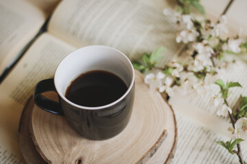 book and a cup of coffee with spring twig blooming