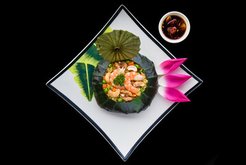 Fototapeta na wymiar Vietnamese fried rice with vegetables, nuts and shrimps in lotus leaf isolated for a menu