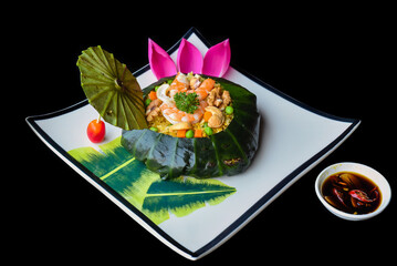 Vietnamese fried rice with vegetables, nuts and shrimps in lotus leaf isolated for a menu