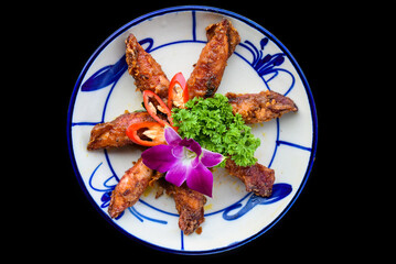 Fried squid with vegetables on black background for a menu