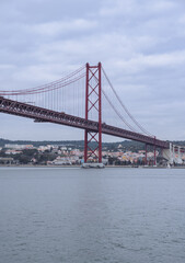 Fototapeta na wymiar View of the 25 April bridge from the Tagus river in Lisbon (Portugal). Europe's longest bridge connecting the city of Lisbon.