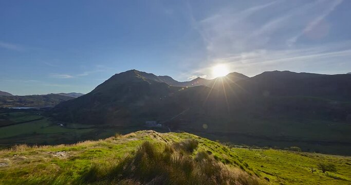 Panning Time Lapse of setting sun at sunset  of the Snowdonia mountain range in background, Wales, United Kingdom