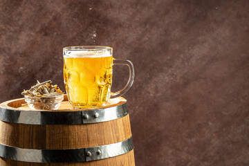 Beer glass and dried fish snack on wooden barrel. banner, menu, recipe place for text