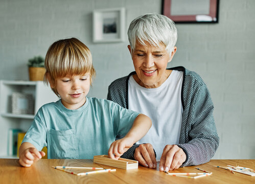 grandchild family child grandparent grandmother game playing boy stick pick up board board game grandson creativity education