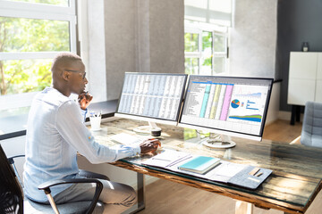 African American Business Desktop Looking At Graphs
