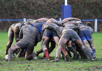 les joueurs de rugby en mêlée dans la boue