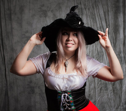 Cheerful young blonde dressed as a good witch, pointed hat on her head