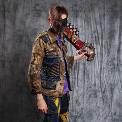 Post-apocalyptic or cyber punk bandit in mask and grunge outfit with weapons for robbery and assault