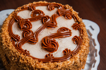Biscuit baked cake with boiled condensed milk and chocolate. Pastry.