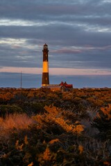 Scenic view of a lighthouse in the distance, set against a backdrop of dark clouds