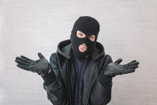 Young handsome man wearing burglar mask clueless and confused with open arms, no idea concept. thief apologizes. justification for arrest