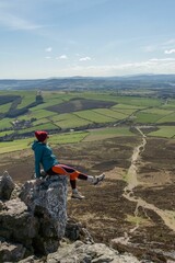 High angle shot of a hiker enjoying the view from the Sugar Loaf Mountain Viewpoint in Ireland
