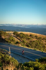 A vertical high angle shot of a cyclist on a scenic mountain trail in Woodside, California