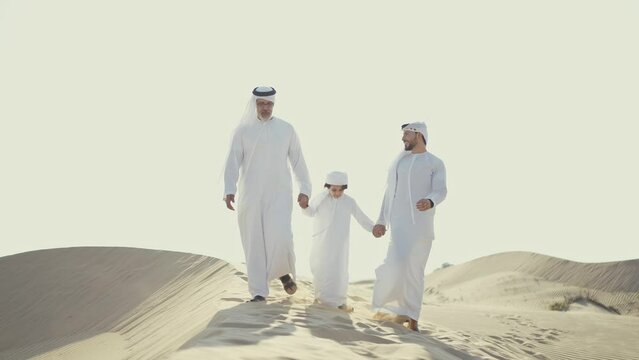 Three generation family spending time in the desert making a safari in Dubai. Concept about middle eastern cultures and lifestyle in the emirates