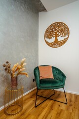 Interior of a contemporary living room with a green velvet armchair and a coffee table