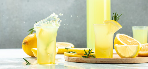 Italian traditional liqueur limoncello with lemon. Long banner format