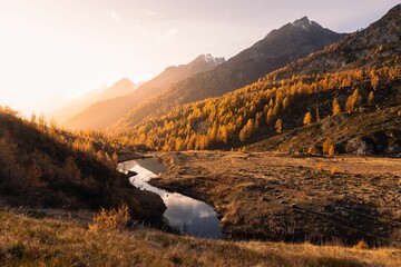 Landscape view of an autumn sunset over the Grundsee mountain lake surrounded by golden larches