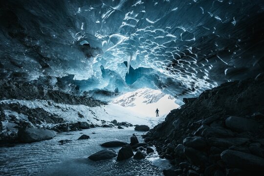 Hiker silhouette exploring an ice cave in the Langgletscher in Loetschental