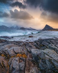 Majestic seascape with snow-capped mountains and dramatic clouds in the background