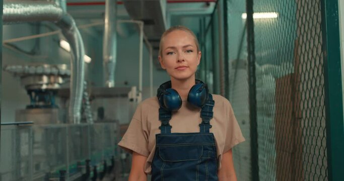 happy smiling blonde female employee in uniform walks large warehouse, close up portrait slow motion successful technology girl is working in laboratory experiment on pesticides. agricultural