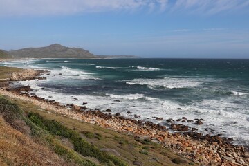 Fototapeta na wymiar Breathtaking view of a turquoise-hued ocean, with rocks on the shoreline. Cape of Good Hope.
