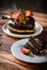 Delicious chocolate cake with strawberries on a wooden table