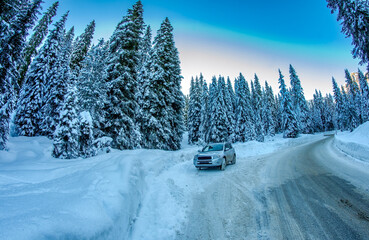 Car speeds up along a winter mountain road surrounded by snow