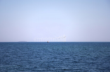 Wind turbine farm power genarator in beautiful nature landscape for production of renewable green energy.