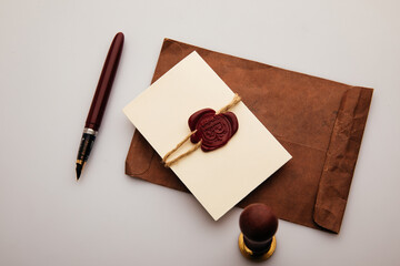 Envelope with wax stamp and pen on a table. Top view.