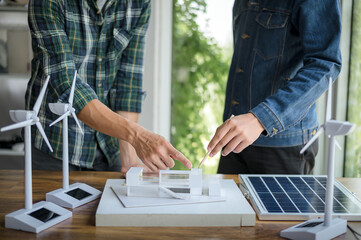Close-up at tablet, Engineers pointing at tablet with their hands. To jointly design the use of renewable energy with wind and solar energy. Concept of using renewable energy.
