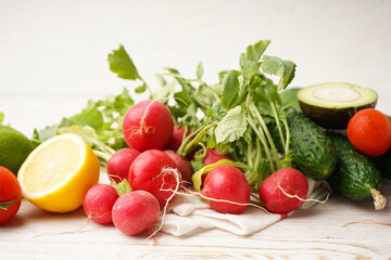 Radish and other spring vegetables on a wooden background, close-up.